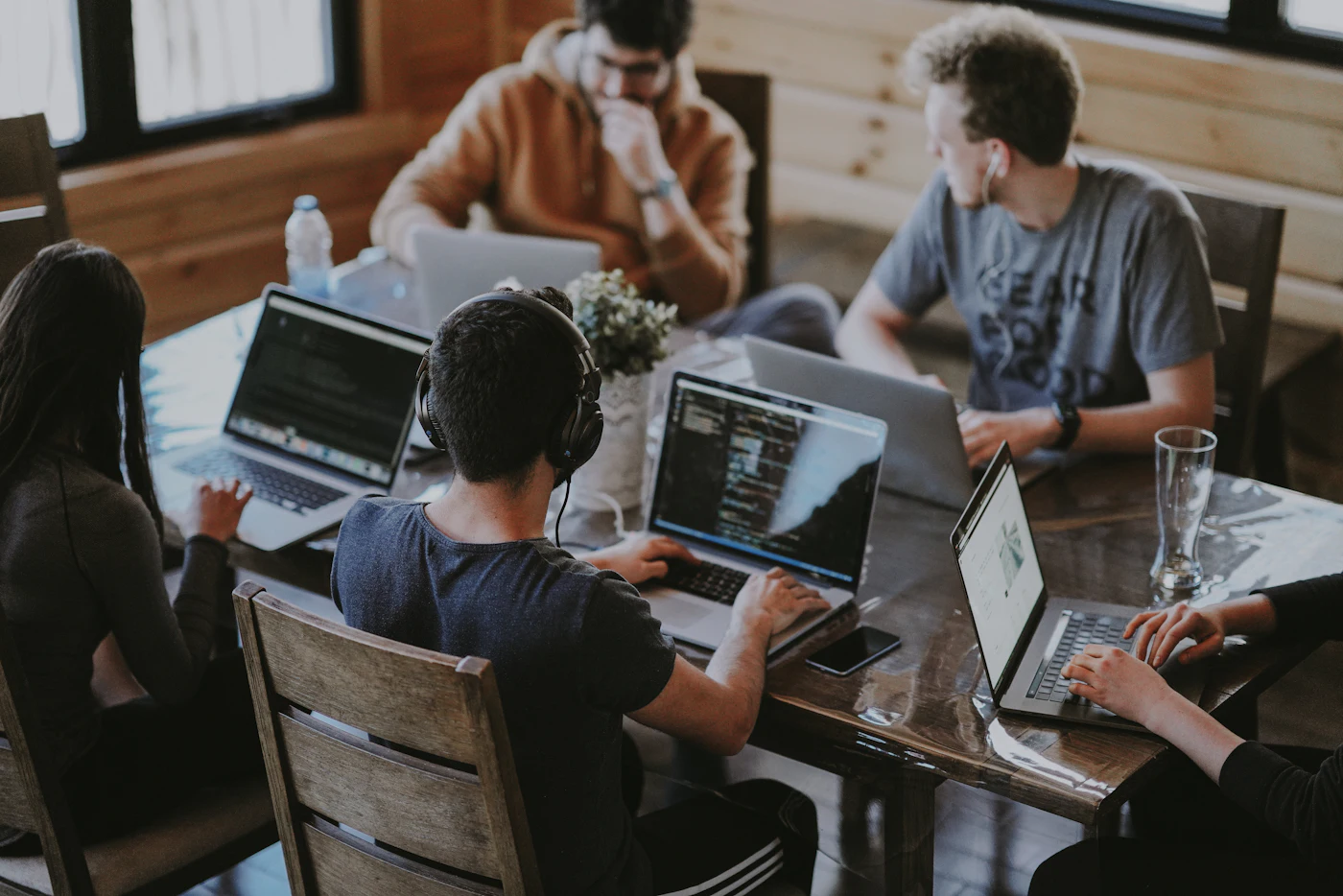 Equipe colaborando em um projeto de tecnologia com computadores